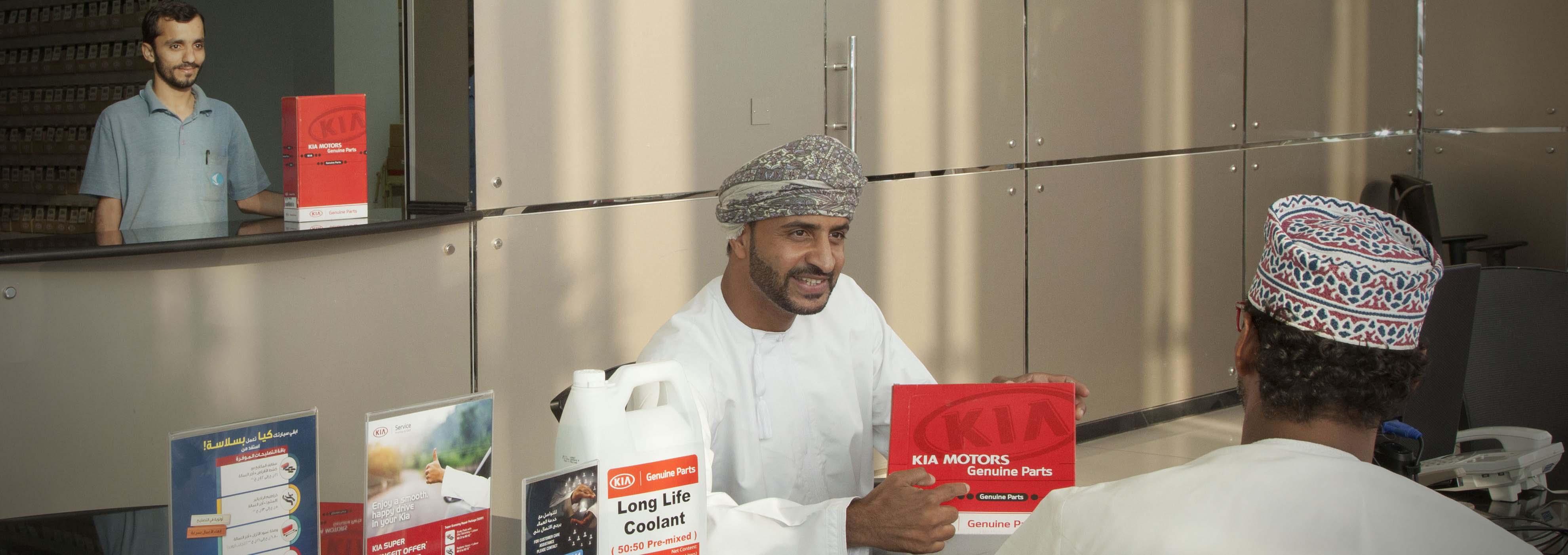 Saud Bahwan's Kia dealership employee explaining about genuine kia parts to a customer