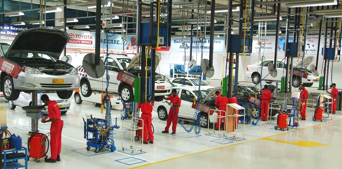 Toyota service centre with multiple employees doing car servicing in red uniforms
