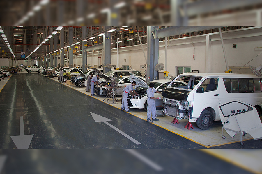 Side view of employees performing car servicing of a toyota car